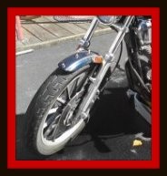 Motorcycle with front wheel turned to left to have right side cleaned by Fifty Dollar Detail.
